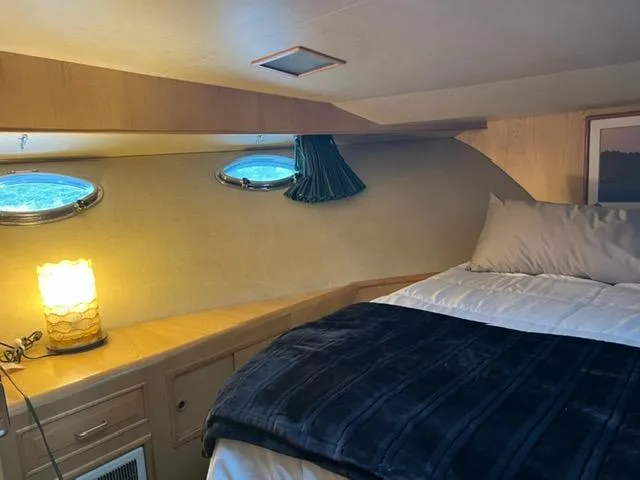  Yacht Photos Pics Cozy cabin interior of 1989 Ocean Alexander 42 yacht with bed and ambient lighting.