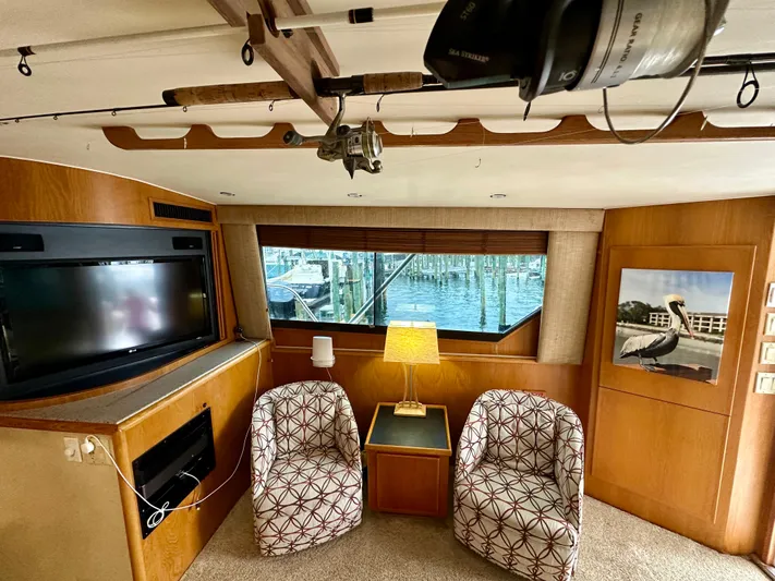 Billie Jo Yacht Photos Pics Interior of 1994 Hatteras 46 Convertible yacht with chairs, TV, and window view.