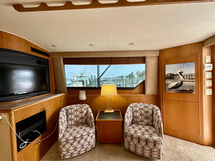 Billie Jo Yacht Photos Pics Interior of 1994 Hatteras 46 Convertible yacht with chairs, lamp, and window view.