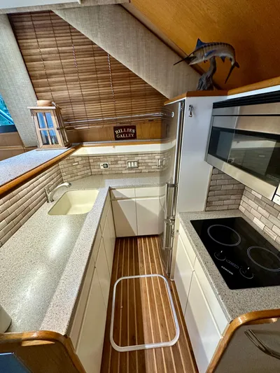 Billie Jo Yacht Photos Pics 1994 Hatteras 46 Convertible yacht kitchen with modern appliances and wooden accents.