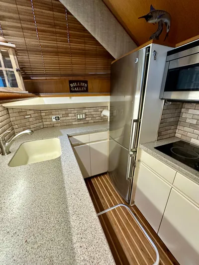 Billie Jo Yacht Photos Pics 1994 Hatteras 46 Convertible yacht kitchen with modern appliances and wood accents.