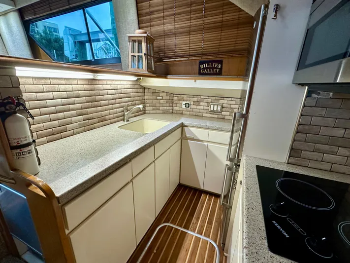 Billie Jo Yacht Photos Pics 1994 Hatteras 46 Convertible yacht kitchen with modern appliances and wooden flooring.