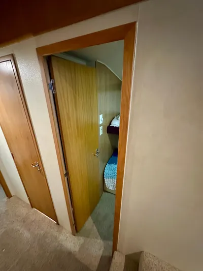 Billie Jo Yacht Photos Pics 1994 Hatteras 46 Convertible interior cabin with wooden door and cozy bedding.