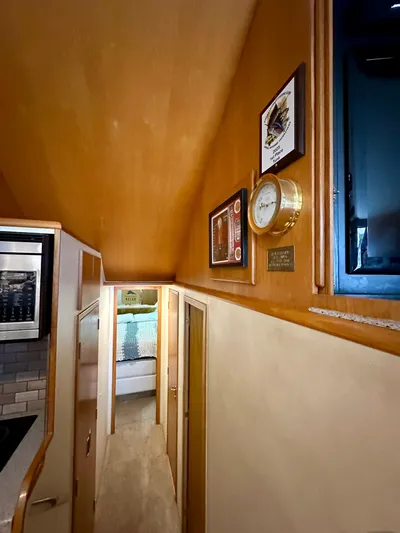 Billie Jo Yacht Photos Pics Interior hallway of 1994 Hatteras 46 Convertible yacht with wood paneling and nautical decor.
