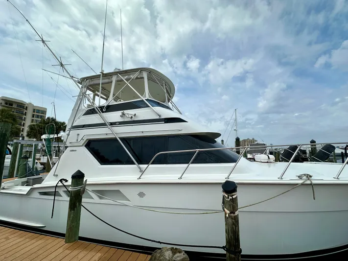 Billie Jo Yacht Photos Pics 1994 Hatteras 46 Convertible yacht docked under a cloudy sky.