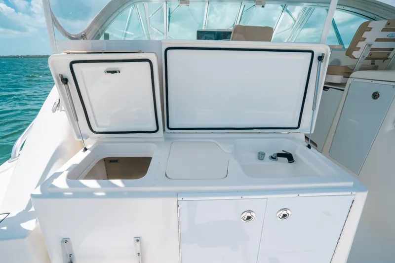  Yacht Photos Pics 2007 Rampage 38 Express boat with open storage compartments and sink on deck.