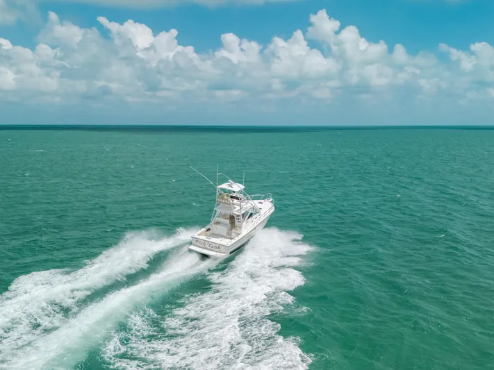  Yacht Photos Pics 2007 Rampage 38 Express boat cruising on turquoise ocean under a partly cloudy sky.