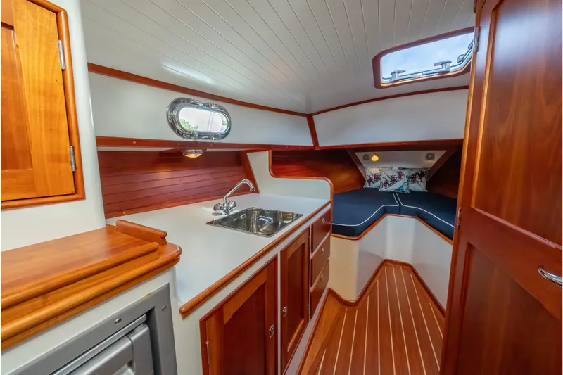 Eloise Yacht Photos Pics 2020 CH Marine Shelter Island Nomad interior with wooden cabinetry and compact kitchenette.