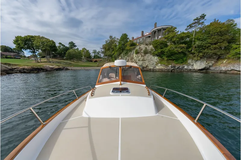 Eloise Yacht Photos Pics 2020 CH Marine Shelter Island Nomad cruising near scenic rocky shoreline and lush greenery.