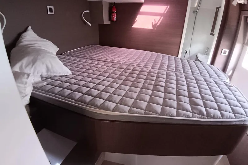  Yacht Photos Pics Cozy cabin bed in 2021 Bali Catamarans 4.8, featuring quilted mattress and pillows.