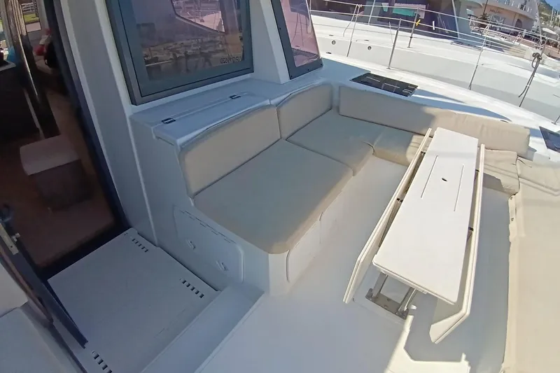  Yacht Photos Pics 2021 Bali Catamarans 4.8 interior with beige seating and foldable table on deck.