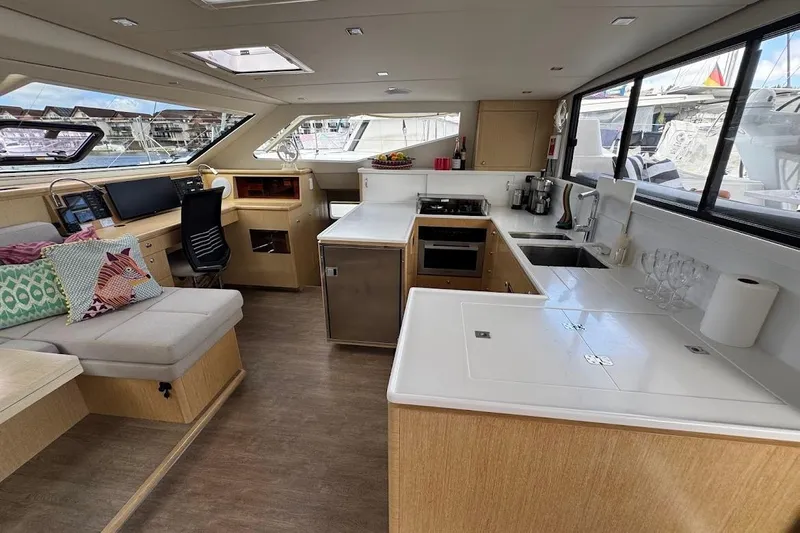 Pure Joy Yacht Photos Pics Luxurious interior of 2023 Seawind 1600 Passagemaker yacht with modern kitchen and seating area.