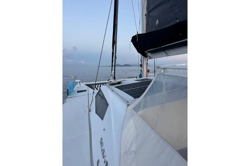 Pure Joy Yacht Photos Pics 2023 Seawind 1600 Passagemaker sailing on calm waters at sunset.