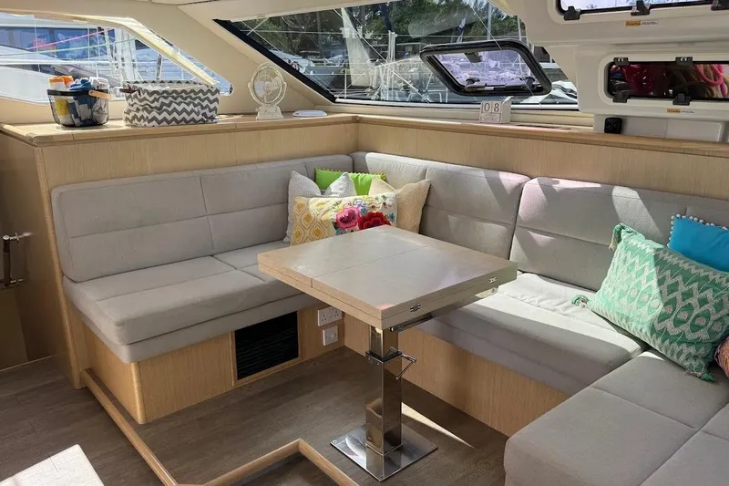 Pure Joy Yacht Photos Pics Luxurious interior of 2023 Seawind 1600 Passagemaker with cozy seating and vibrant cushions.