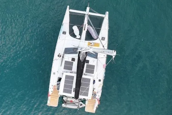 Pure Joy Yacht Photos Pics Aerial view of 2023 Seawind 1600 Passagemaker catamaran on blue water.