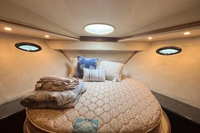Kiki's Tiki Yacht Photos Pics Cozy bedroom in 2000 Carver 506 Motor Yacht with round bed and porthole windows.