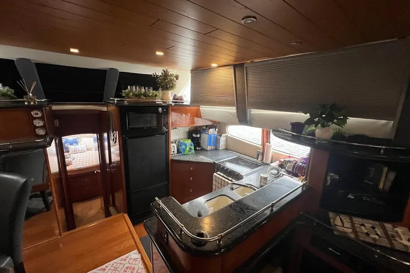 Kiki's Tiki Yacht Photos Pics Interior of 2000 Carver 506 Motor Yacht with modern kitchen and wooden accents.