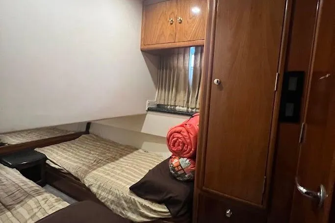 Kiki's Tiki Yacht Photos Pics Cozy bedroom in 2000 Carver 506 Motor Yacht with wood cabinets and window.