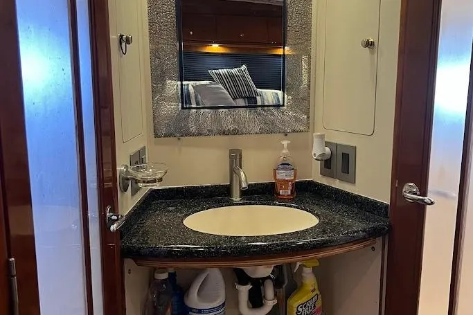 Kiki's Tiki Yacht Photos Pics Bathroom vanity in 2000 Carver 506 Motor Yacht with mirror and cleaning supplies.