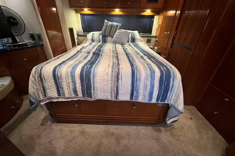 Kiki's Tiki Yacht Photos Pics Luxurious bedroom interior of 2000 Carver 506 Motor Yacht with striped bedding.