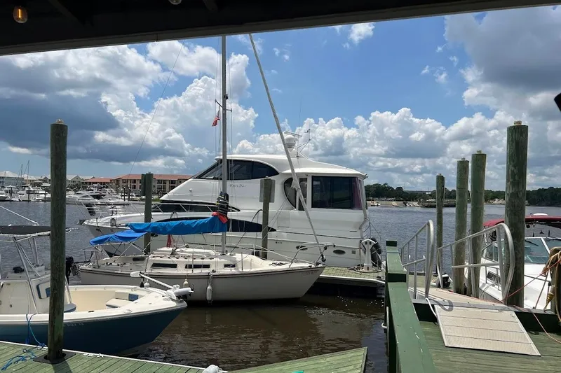 Kiki's Tiki Yacht Photos Pics 2000 Carver 506 Motor Yacht docked at a marina under a partly cloudy sky.