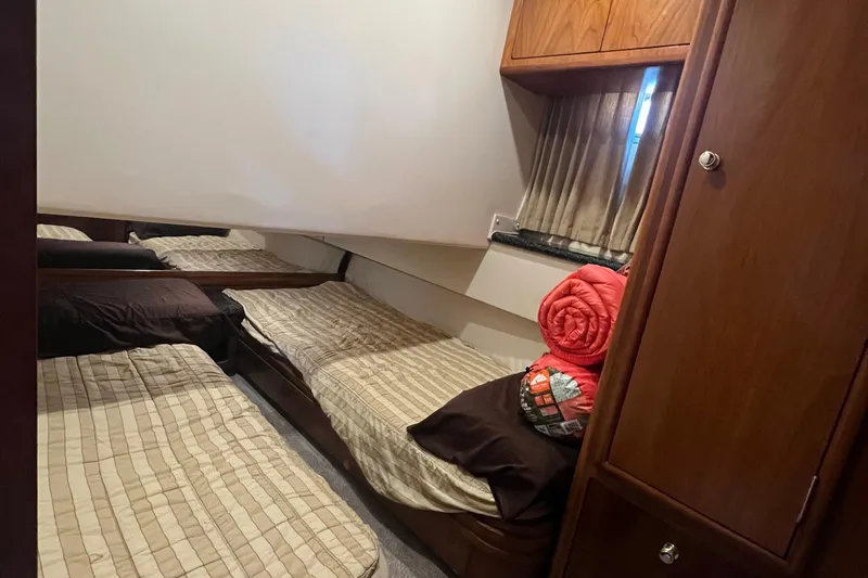 Kiki's Tiki Yacht Photos Pics Interior cabin of 2000 Carver 506 Motor Yacht with twin beds and wooden cabinetry.