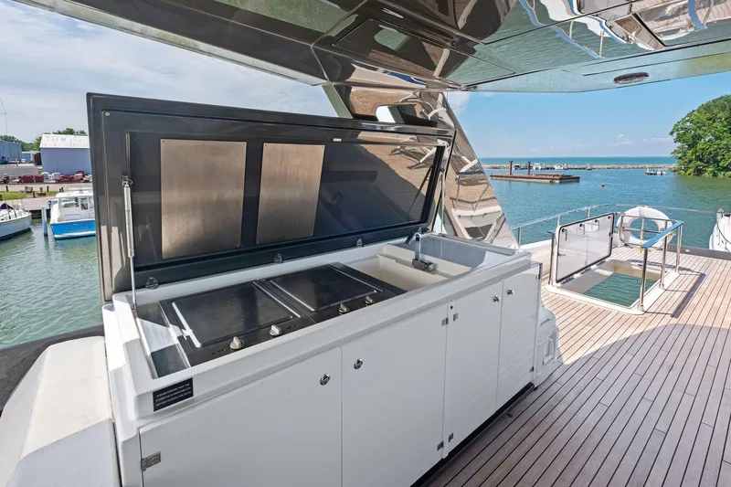 She Said Yes! Again Yacht Photos Pics Outdoor kitchen on 2018 Ferretti Yachts 780, featuring a grill and sink, overlooking serene waters.