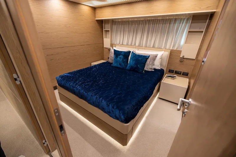 Life: For Sale Yacht Photos Pics Luxurious bedroom interior of 2021 Ferretti Yachts 920 with elegant blue bedding.