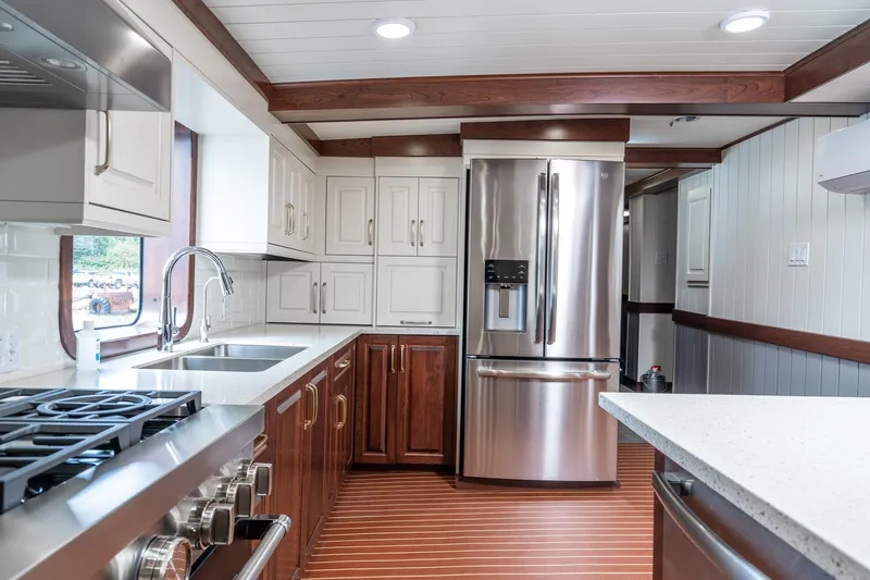 Anne S Pierce Yacht Photos Pics Modern ship kitchen with stainless steel appliances, wood accents, and sleek countertops on an exploration ship.