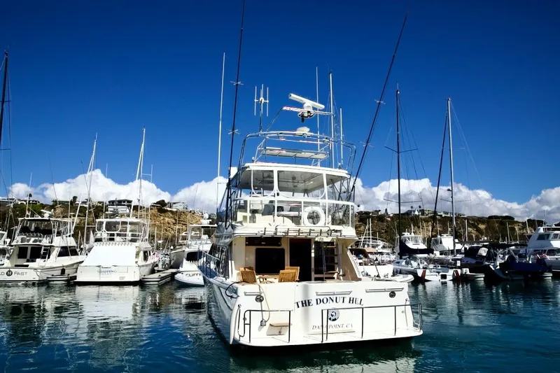 The Donut Hull Yacht Photos Pics Mikelson 50 Sportfisher 2002 yacht docked in a marina under clear blue skies.