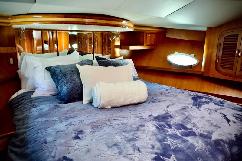 The Donut Hull Yacht Photos Pics Luxurious cabin interior of 2002 Mikelson 50 Sportfisher with plush bedding and wood accents.