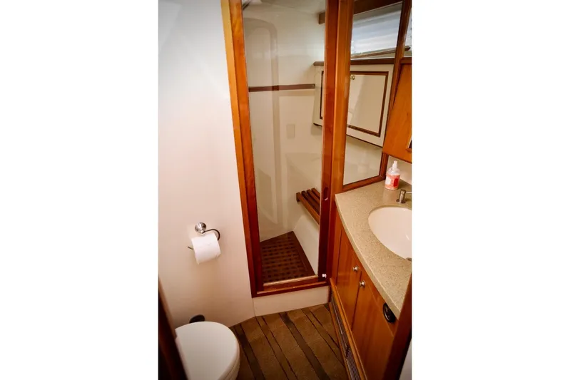 The Donut Hull Yacht Photos Pics Bathroom interior of 2002 Mikelson 50 Sportfisher yacht with wooden accents and modern fixtures.
