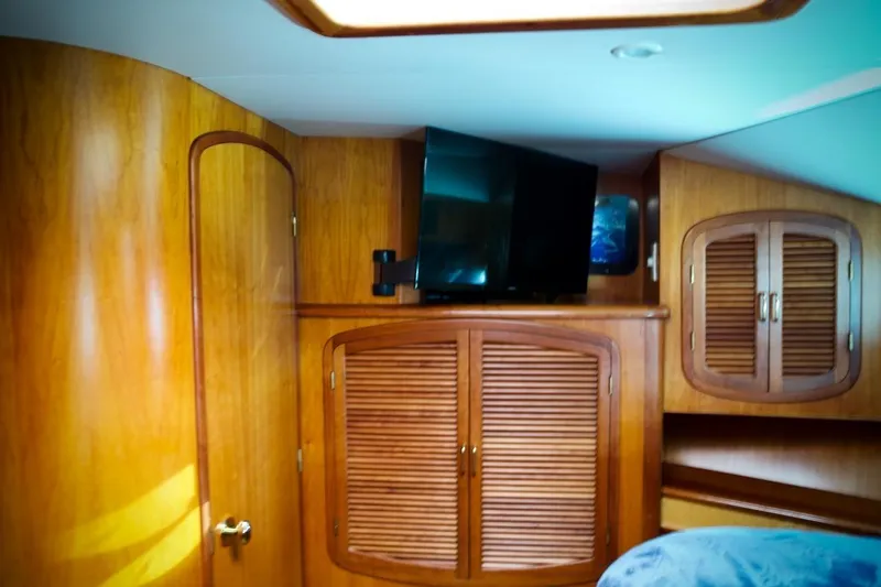 The Donut Hull Yacht Photos Pics Interior of 2002 Mikelson 50 Sportfisher with wooden cabinets and mounted TV.