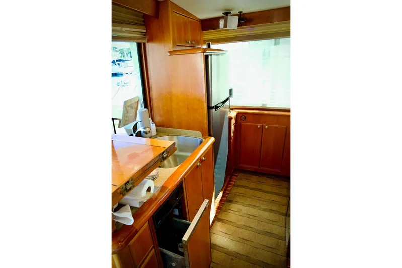 The Donut Hull Yacht Photos Pics Interior of 2002 Mikelson 50 Sportfisher yacht with wooden cabinetry and modern appliances.