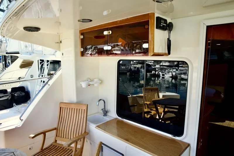 The Donut Hull Yacht Photos Pics 2002 Mikelson 50 Sportfisher yacht interior with wooden chair, sink, and marina view.
