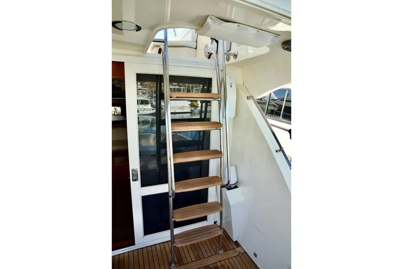 The Donut Hull Yacht Photos Pics Stainless steel and wood ladder on 2002 Mikelson 50 Sportfisher yacht.