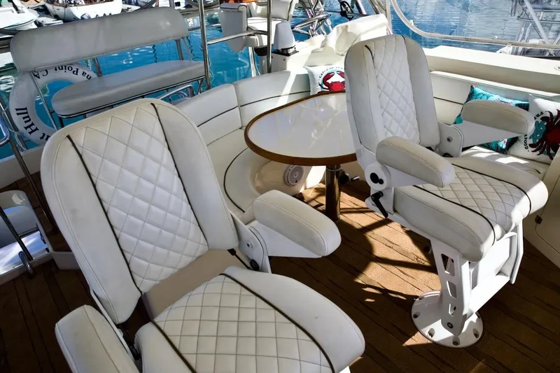 The Donut Hull Yacht Photos Pics Luxurious seating on 2002 Mikelson 50 Sportfisher yacht with white quilted chairs and wooden deck.