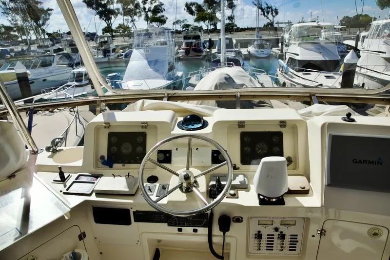 The Donut Hull Yacht Photos Pics Helm of 2002 Mikelson 50 Sportfisher with Garmin navigation, docked among other boats.