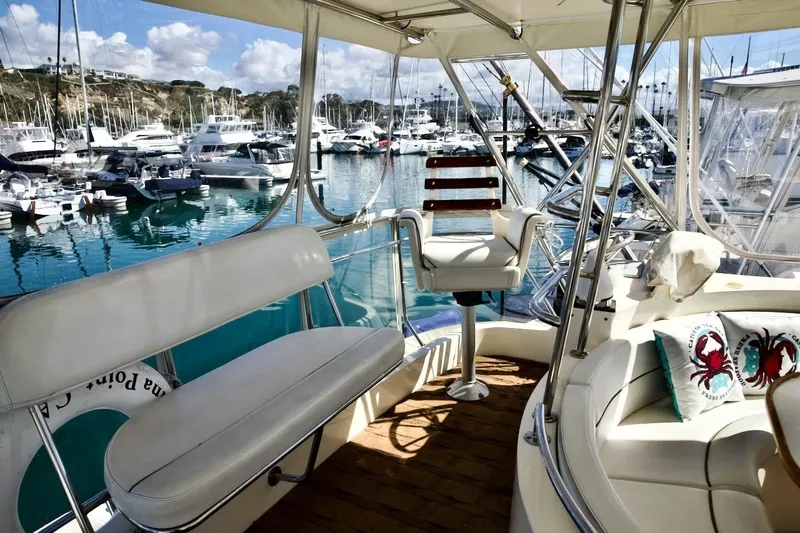 The Donut Hull Yacht Photos Pics Luxurious 2002 Mikelson 50 Sportfisher yacht interior at marina, featuring plush seating and scenic views.