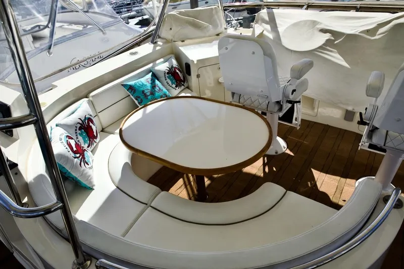 The Donut Hull Yacht Photos Pics Luxurious 2002 Mikelson 50 Sportfisher yacht interior with cushioned seating and table.