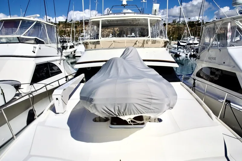 The Donut Hull Yacht Photos Pics 2002 Mikelson 50 Sportfisher yacht docked in marina, covered equipment on deck.