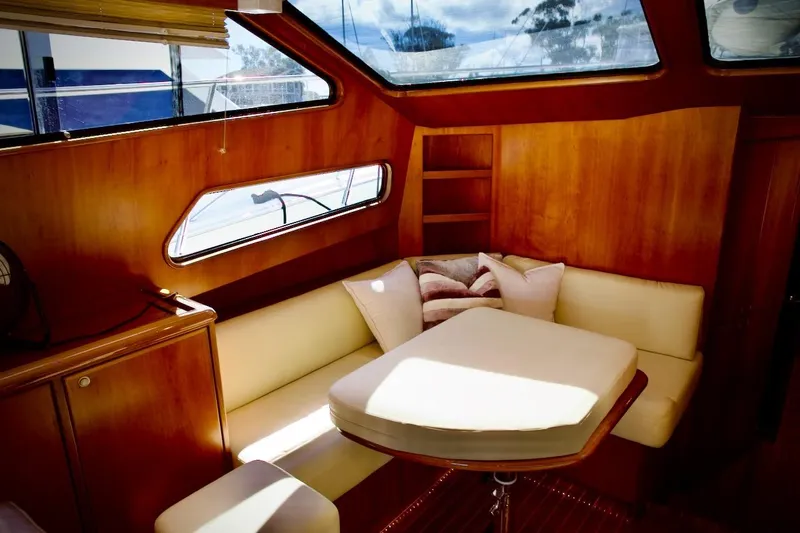 The Donut Hull Yacht Photos Pics Interior of 2002 Mikelson 50 Sportfisher with cozy seating and wooden accents.
