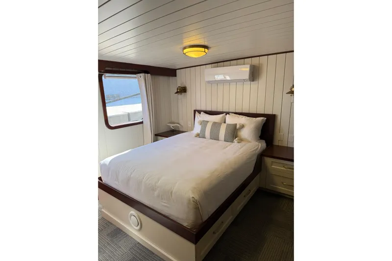 Anne S Pierce Yacht Photos Pics Cozy bedroom in 2021 Custom Glovertown Shipyard boat with elegant wood paneling and window view.