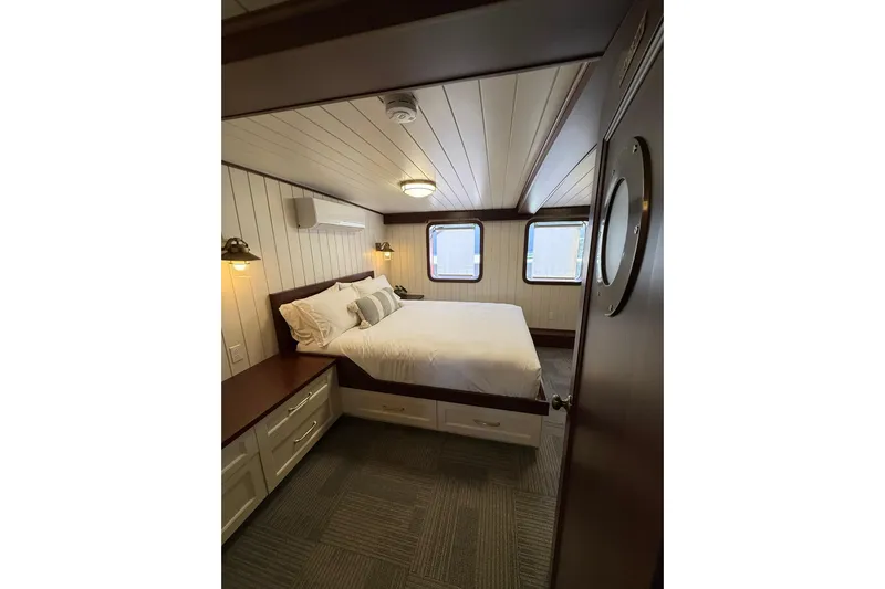 Anne S Pierce Yacht Photos Pics Cozy ship cabin with double bed, porthole windows, and wooden interior, Glovertown Shipyard 2021 model.