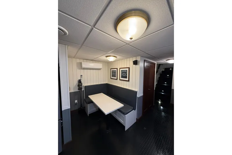 Anne S Pierce Yacht Photos Pics Cozy ship interior with booth seating, modern lighting, and framed artwork, Glovertown Shipyard 2021.