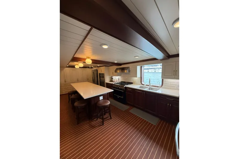 Anne S Pierce Yacht Photos Pics Luxurious ship kitchen with modern appliances, island seating, and ocean view window, 2021 Glovertown Shipyard.