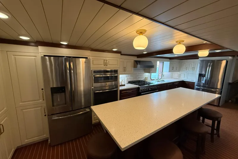 Anne S Pierce Yacht Photos Pics Luxurious ship kitchen with modern appliances, large island, and elegant lighting, Custom Glovertown Shipyard 2021.
