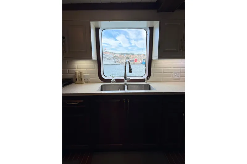 Anne S Pierce Yacht Photos Pics Modern ship kitchen with a large window view, featuring a sleek sink and countertop.