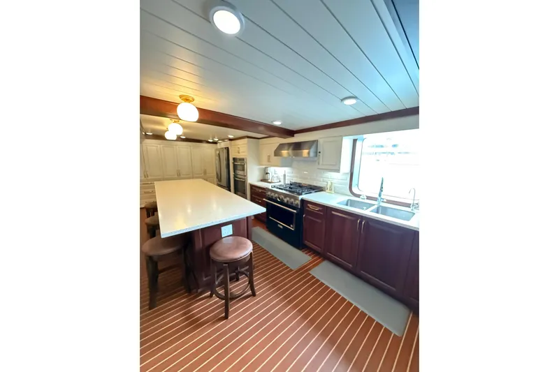 Anne S Pierce Yacht Photos Pics Luxurious ship kitchen with island, modern appliances, and wood accents, 2021 Glovertown Shipyard.