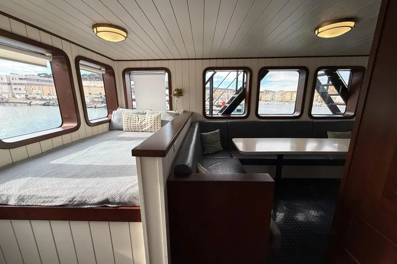 Anne S Pierce Yacht Photos Pics Cozy ship interior with bed, dining area, and large windows, Custom Glovertown Shipyard 2021.